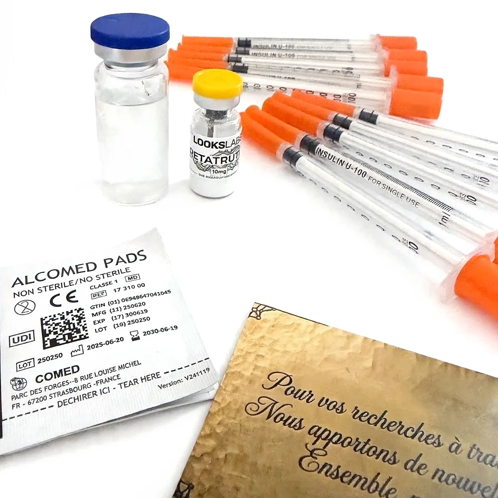 Photo réelle d’un colis LooksLabs : flacon de Retatrutide 10 mg, eau bactériostatique, seringues, lingettes alcoolisées et carte LooksLabs
