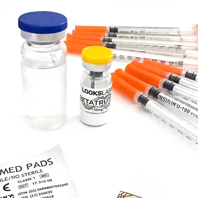Photo réelle d’un flacon LooksLabs de Retatrutide 10 mg (capsule jaune) à côté de l’eau bactériostatique, des seringues et des tampons du kit de reconstitution